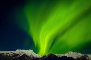 Generic copy space banner aurora borealis northern lights show over snowy white mountain peaks photo