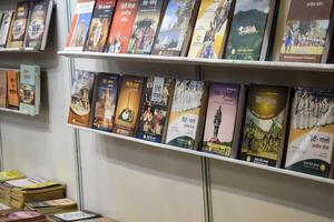 New Delhi, India, May 31 2024 - Variety of Books on shelf inside a book-stall at Delhi International Book Fair, Selection of books on display in Annual Book Fair at Bharat Mandapam complex photo