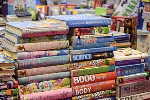 New Delhi, India, May 17 2024 - Variety of Books on shelf inside a book-stall at Delhi International Book Fair, Selection of books on display in Annual Book Fair at Bharat Mandapam complex photo