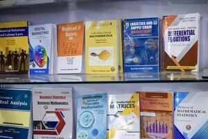 New Delhi, India, May 17 2024 - Variety of Books on shelf inside a book-stall at Delhi International Book Fair, Selection of books on display in Annual Book Fair at Bharat Mandapam complex photo