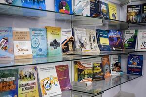 New Delhi, India, February 17 2024 - Variety of Books on shelf inside a book-stall at Delhi International Book Fair, Selection of books on display in Annual Book Fair at Bharat Mandapam complex photo