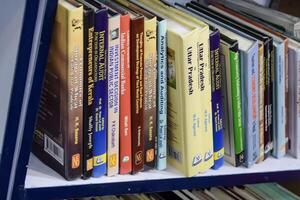 New Delhi, India, February 17 2024 - Variety of Books on shelf inside a book-stall at Delhi International Book Fair, Selection of books on display in Annual Book Fair at Bharat Mandapam complex photo