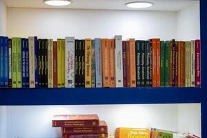 New Delhi, India, February 17 2024 - Variety of Books on shelf inside a book-stall at Delhi International Book Fair, Selection of books on display in Annual Book Fair at Bharat Mandapam complex photo