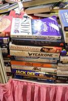 New Delhi, India, May 17 2024 - Variety of Books on shelf inside a book-stall at Delhi International Book Fair, Selection of books on display in Annual Book Fair at Bharat Mandapam complex photo