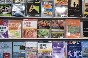 New Delhi, India, February 17 2024 - Variety of Books on shelf inside a book-stall at Delhi International Book Fair, Selection of books on display in Annual Book Fair at Bharat Mandapam complex photo