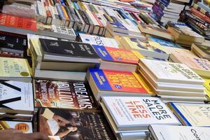 New Delhi, India, May 7 2024 - Variety of Books on shelf inside a book-stall at Delhi International Book Fair, Selection of books on display in Annual Book Fair at Bharat Mandapam complex photo