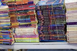 New Delhi, India, May 17 2024 - Variety of Books on shelf inside a book-stall at Delhi International Book Fair, Selection of books on display in Annual Book Fair at Bharat Mandapam complex photo