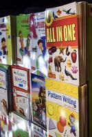 New Delhi, India, February 17 2024 - Variety of Books on shelf inside a book-stall at Delhi International Book Fair, Selection of books on display in Annual Book Fair at Bharat Mandapam complex photo