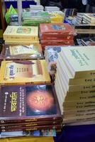 New Delhi, India, February 17 2024 - Variety of Books on shelf inside a book-stall at Delhi International Book Fair, Selection of books on display in Annual Book Fair at Bharat Mandapam complex photo