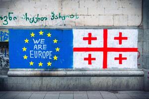 Tbilisi, Georgia - 16th may, 2024 - Eu and Georgian flag on wall, statement -we are EUROPE. No russian law movement. Integration process to EU concept photo