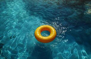 Yellow float ring in a blue swimming pool with sparkling water, sunlight reflecting off the surface. photo