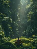 A person is sitting in a lush green forest, surrounded by trees and plants photo