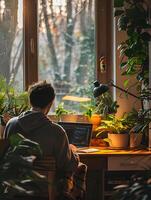 A man is sitting at a desk with a laptop in front of him photo