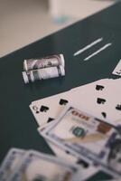 Blured Rolled 100 us dollars, 2 lines of cocaine, illegal drugs on a black glass table. Drug addiction. With selective focus photo
