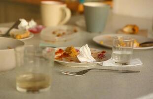 Empty dirty plates with spoons and forks on the table after meal. Banquet ending concept. Unwashed dishes photo