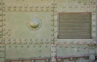 The texture of the wall of the tank, made of metal and reinforced with a multitude of bolts and rivets. Images of the covering of a combat vehicle from the Second World War photo