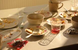 Empty dirty plates with spoons and forks on the table after meal. Banquet ending concept. Unwashed dishes photo