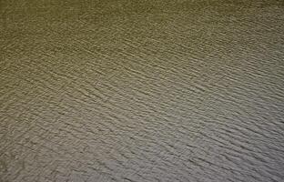 The texture of dark river water under the influence of wind, imprinted in perspective. Horizontal image photo