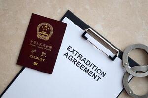Passport of China Republic and Extradition Agreement with handcuffs on table photo