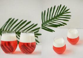 Cocktail in transparent glasses. Layers of jelly and whipped cream. Strawberry cocktail on a white background with a leaf of palm tree.Exotic. Collage photo