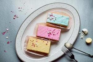 Beautiful delicate shortbread cakes with icing of delicate colors. Tea party for the holiday. Confectionery art.The view from the top, the background is silver. photo