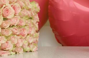 Bouquet of colorful roses and red balloons in shape of heart. Pink flowers full frame photo