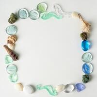 The layout of sea shells, the artwork from the sea.Little things to remember your vacation. The form of a square. An empty space in the middle. photo