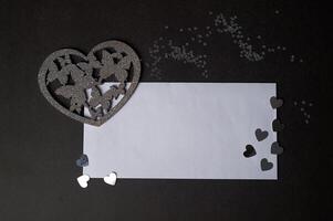 Valentine's day,a Declaration of love. Silver heart with butterflies. Butterflies in the stomach. Silver heart with butterflies on a dark graphite background.And a white envelope for the inscription photo