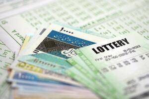 Green lottery tickets and iranian money bills on blank with numbers for playing lottery photo