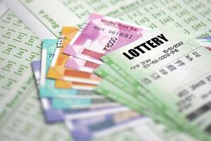 Green lottery tickets and indian rupees money bills on blank with numbers for playing lottery photo