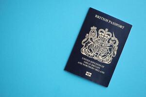 Blue British passport on blue background close up photo