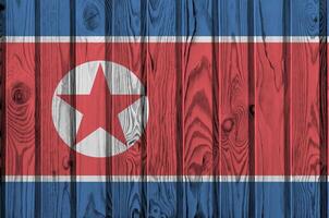 North Korea flag depicted in bright paint colors on old wooden wall. Textured banner on rough background photo