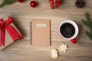 2025 notebook, black coffee cup, Christmas cookies and pen on wood table, Top view and copy space. Xmas, Happy New Year, Goals, Resolution, To do list, Strategy and Plan concept photo
