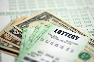 Green lottery tickets and US money bills on blank with numbers for playing lottery photo
