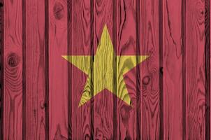 Vietnam flag depicted in bright paint colors on old wooden wall. Textured banner on rough background photo