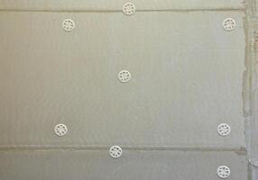 The texture of the wall, covered with gray foam polystyrene plates, which are reinforced with plastic umbrella dowels. Stage of wall insulation photo