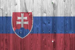 Slovakia flag depicted in bright paint colors on old wooden wall. Textured banner on rough background photo