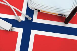 Norway flag depicted on table with internet rj45 cable, wireless usb wifi adapter and router. Internet connection concept photo