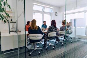Diverse Business Team Discussing Projects in a Modern Glass Office. photo