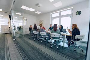 Diverse Business Team Discussing Projects in a Modern Glass Office. photo