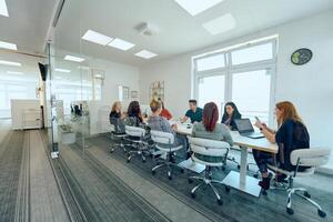 Diverse Business Team Discussing Projects in a Modern Glass Office. photo
