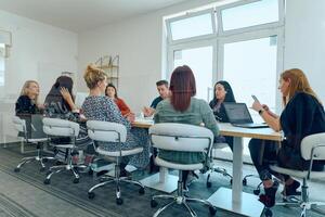 Diverse Business Team Discussing Projects in a Modern Glass Office. photo