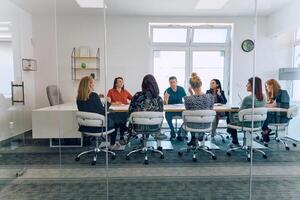Diverse Business Team Discussing Projects in a Modern Glass Office. photo