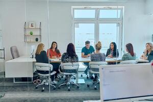 Diverse Business Team Discussing Projects in a Modern Glass Office. photo