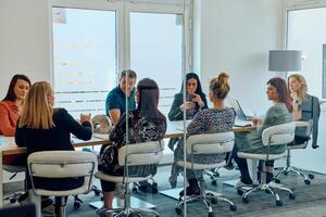 Diverse Business Team Discussing Projects in a Modern Glass Office. photo