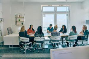 Diverse Business Team Discussing Projects in a Modern Glass Office. photo