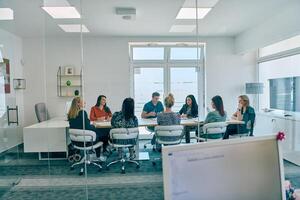Diverse Business Team Discussing Projects in a Modern Glass Office. photo