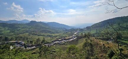 Beautiful scenery on top of hill, green view and blue sky with clouds, location at puncak pass, bogor, indonesia photo