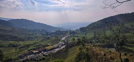 Beautiful scenery on top of hill, green view and blue sky with clouds, location at puncak pass, bogor, indonesia photo