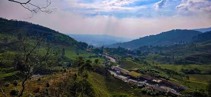 Beautiful scenery on top of hill, green view and blue sky with clouds, location at puncak pass, bogor, indonesia photo